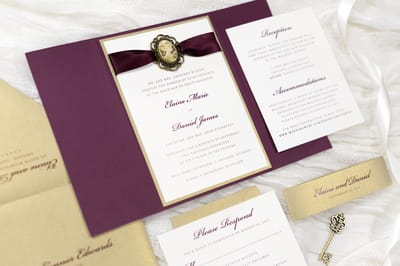 elegant and formal gatefold wedding invitation with vintage style cameo silhouette ribbon embellishment in ivory, gold leaf, and wine / burgundy