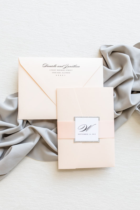 elegant formal white silver glitter and blush metallic shimmer pocketfold wedding invitation suite with satin ribbon belly band monogram