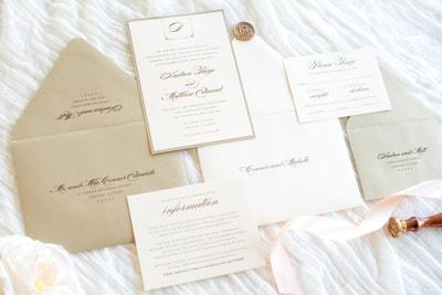 soft blush and gold shimmer luxury wedding invitation with elegant monogram crest and wax seal