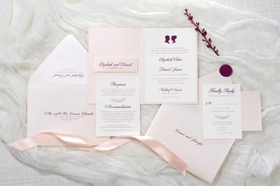 elegant and formal folding blush and opal shimmer wedding invitation with cameo silhouette wax seal and belly band