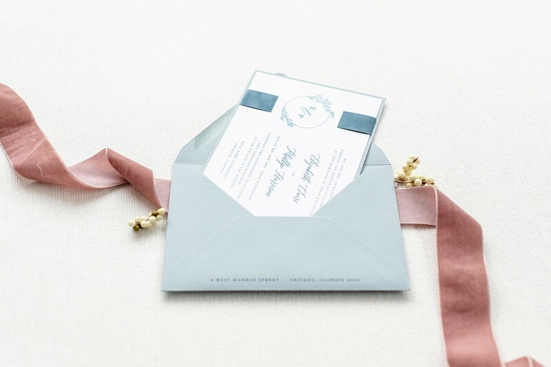 elegant & formal wedding invitation with velvet ribbon band in white, dusty blue, french blue, and floral branch fern foliage monogram crest