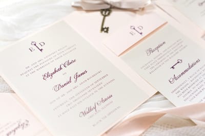 elegant and formal vintage style key charm wedding invitation in blush, opal shimmer, and burgundy with vellum sheet and satin ribbon